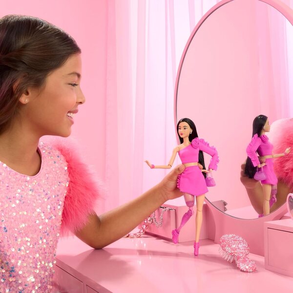 Barbie Deluxe Style Doll #2 in Barbiecore Outfit, Black Hair and Glittery Prosthetic Leg, Pink Top and Skirt Set with Rosette Detail and Accessories