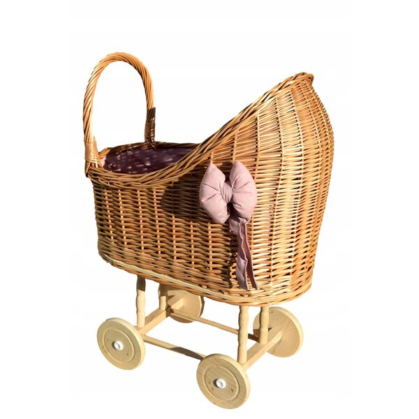 Ein Puppenwagen aus Korbgeflecht mit rosa Besatz und Bettwäsche – solide und natürlich