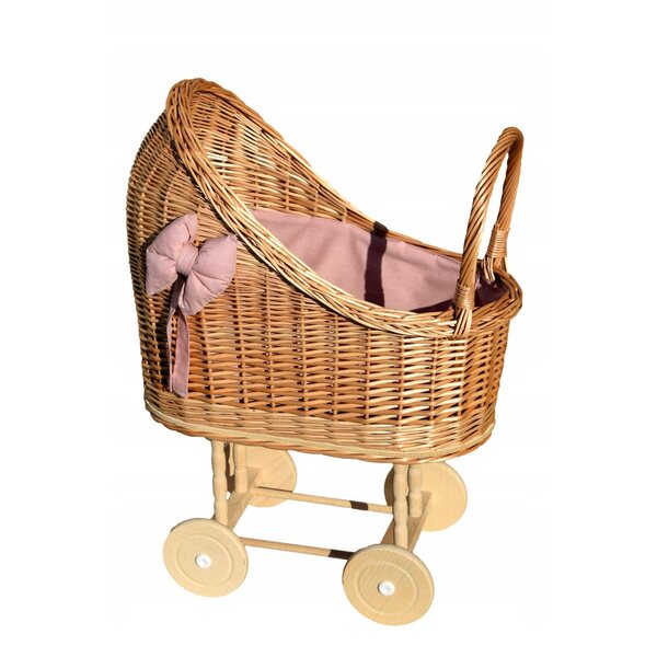 Ein Puppenwagen aus Korbgeflecht mit rosa Besatz und Bettwäsche – solide und natürlich