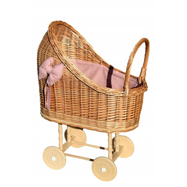 Ein Puppenwagen aus Korbgeflecht mit rosa Besatz und Bettwäsche – solide und natürlich