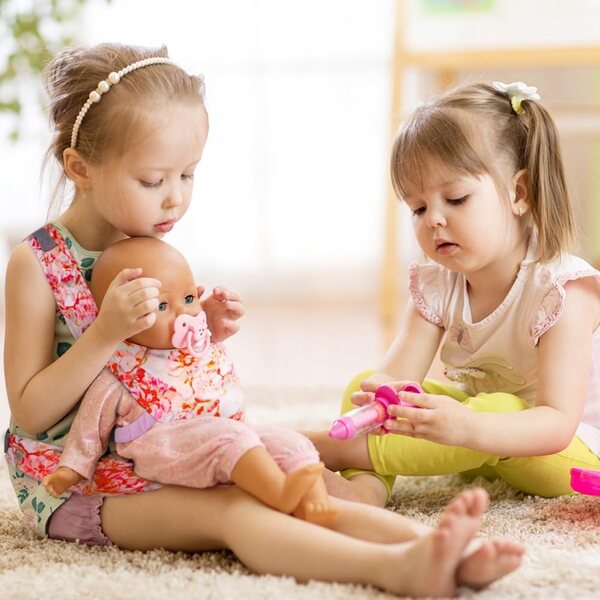 Eine Babytrage für Puppen mit verstellbaren Trägern und Blumenmuster