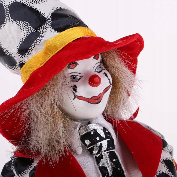 Eine 18 cm große Clownpuppe aus Porzellan, die in einem farbenfrohen Glitzerkostüm lächelt