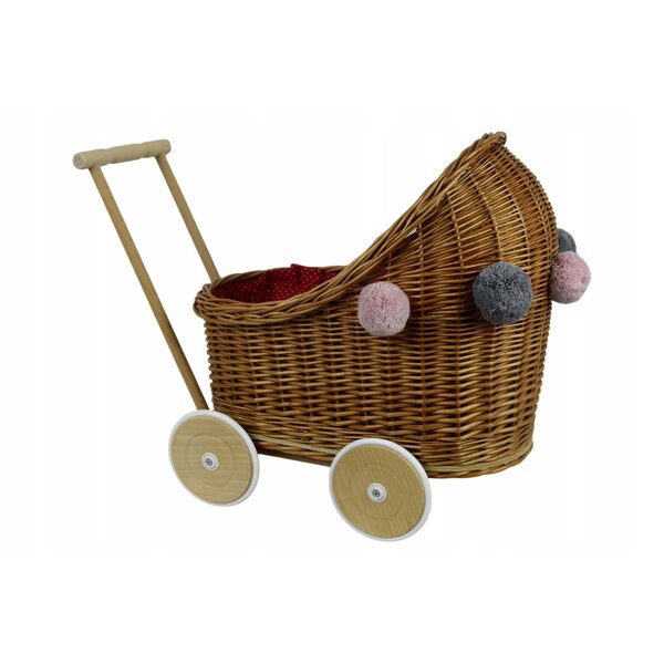 Ein tiefer Puppenwagen aus Korbgeflecht mit Bettwäsche und Pompons für Babys ab 12 Monaten