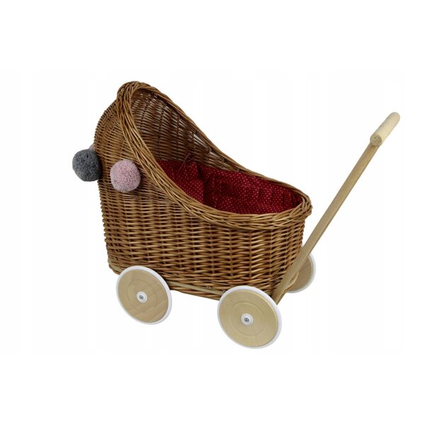 Ein tiefer Puppenwagen aus Korbgeflecht mit Bettwäsche und Pompons für Babys ab 12 Monaten