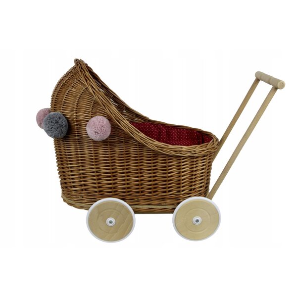 Ein tiefer Puppenwagen aus Korbgeflecht mit Bettwäsche und Pompons für Babys ab 12 Monaten