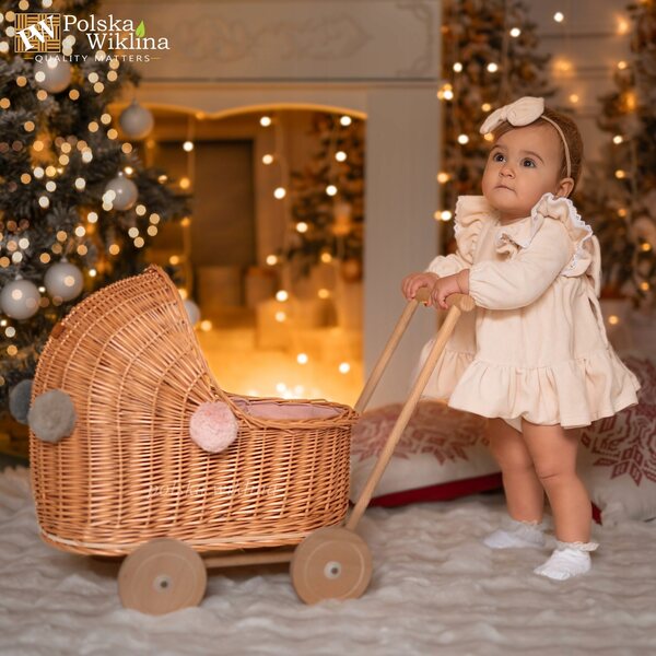 Niedriger Puppenwagen aus Naturgeflecht mit Pompons und rosa Verzierung