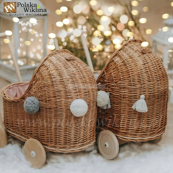 Niedriger Puppenwagen aus Naturgeflecht mit Pompons und rosa Verzierung