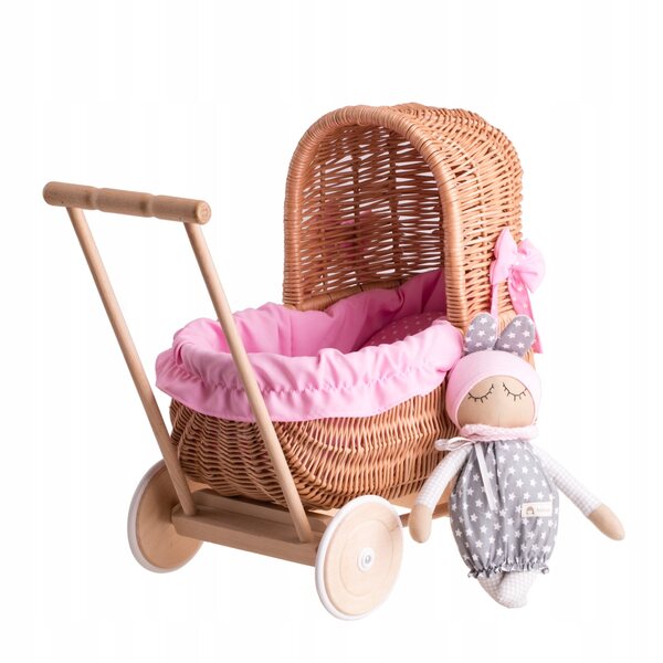 Ein Puppenwagen aus Korbgeflecht mit rosa Besatz, Bettwäsche und Holzgriff
