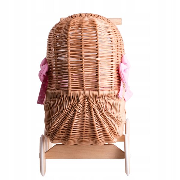 Ein Puppenwagen aus Korbgeflecht mit rosa Besatz, Bettwäsche und Holzgriff