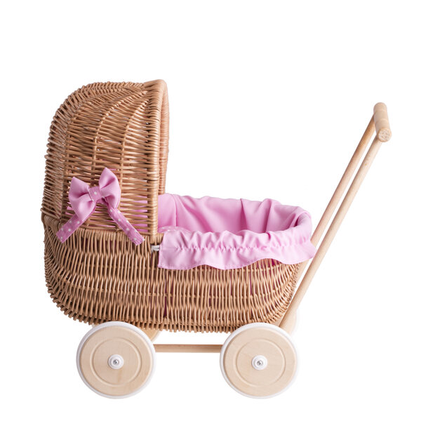 Ein Puppenwagen aus Korbgeflecht mit rosa Besatz, Bettwäsche und Holzgriff