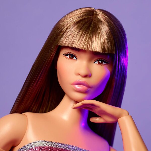 Barbie sieht wie Puppe Nr. 24 mit braunen Haaren und Y2K-Mode in einem glitzernden rosa Kleid aus