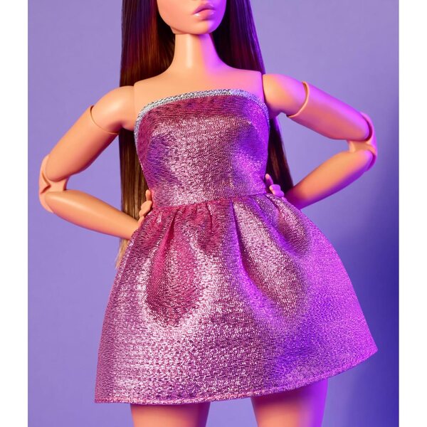 Barbie sieht wie Puppe Nr. 24 mit braunen Haaren und Y2K-Mode in einem glitzernden rosa Kleid aus